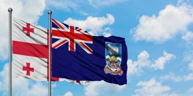 Gürcistan ve Falkland Adaları bayrağı birlikte beyaz bulutlu mavi gökyüzüne karşı rüzgarsal sallayarak. Diplomasi kavramı, uluslararası ilişkiler.