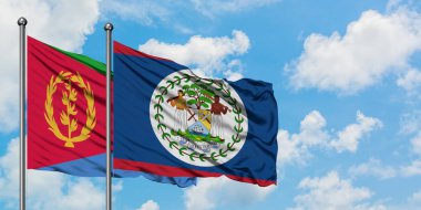Eritre ve Belize bayrağı birlikte beyaz bulutlu mavi gökyüzüne karşı rüzgarda sallayarak. Diplomasi kavramı, uluslararası ilişkiler.