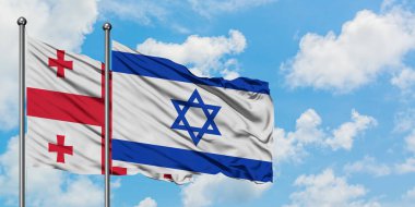 Gürcistan ve İsrail bayrağı birlikte beyaz bulutlu mavi gökyüzüne karşı rüzgarda sallayarak. Diplomasi kavramı, uluslararası ilişkiler.