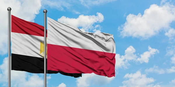 Bandera de Egipto y Polonia ondeando en el viento contra el cielo azul nublado blanco juntos. Concepto diplomático, relaciones internacionales . — Foto de Stock
