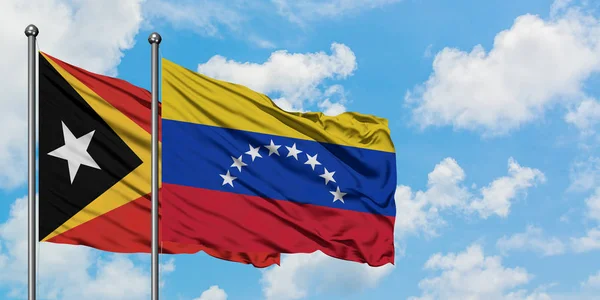 East Timor and Venezuela flag waving in the wind against white cloudy blue sky together. Diplomacy concept, international relations. — Stock Photo, Image