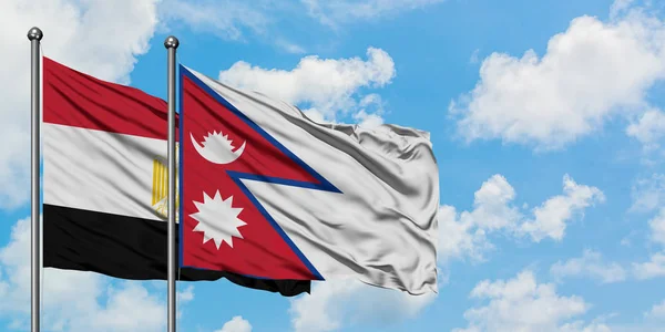 Mısır ve Nepal bayrağı birlikte beyaz bulutlu mavi gökyüzüne karşı rüzgarda sallayarak. Diplomasi kavramı, uluslararası ilişkiler. — Stok fotoğraf
