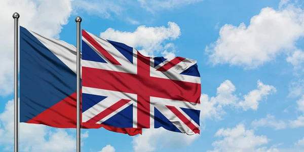 Tjeckien och Storbritannien flagga vifta i vinden mot vit grumlig blå himmel tillsammans. Diplomatisk koncept, internationella relationer. — Stockfoto