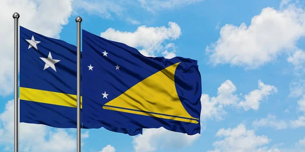 Bandera de Curazao y Tokelau ondeando en el viento contra el cielo azul nublado blanco juntos. Concepto diplomático, relaciones internacionales . — Foto de Stock