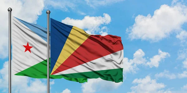 Djibouti and Seychelles flag waving in the wind against white cloudy blue sky together. Diplomacy concept, international relations. — Stock Photo, Image