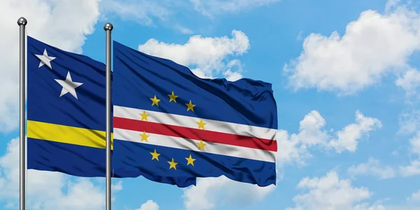 Curaçao e bandeira de Cabo Verde agitando no vento contra o céu azul nublado branco juntos. Conceito de diplomacia, relações internacionais . — Fotografia de Stock