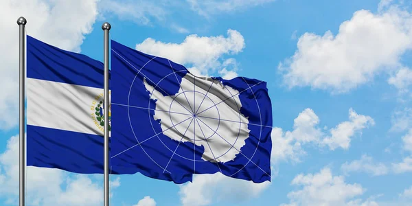 一緒に白い曇った青い空に対して風に手を振るエルサルバドルと南極の旗。外交概念、国際関係. — ストック写真