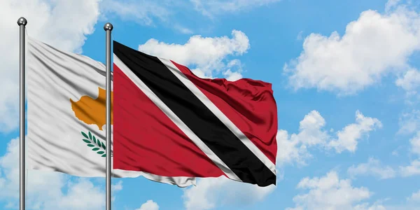 Kıbrıs ve Trinidad ve Tobago bayrağı birlikte beyaz bulutlu mavi gökyüzüne karşı rüzgarda sallayarak. Diplomasi kavramı, uluslararası ilişkiler. — Stok fotoğraf