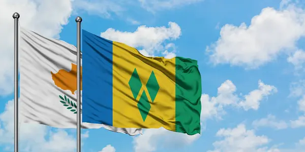 Cyprus en Saint Vincent en de Grenadines vlag zwaaien in de wind tegen witte bewolkte blauwe hemel samen. Diplomatie concept, internationale betrekkingen. — Stockfoto