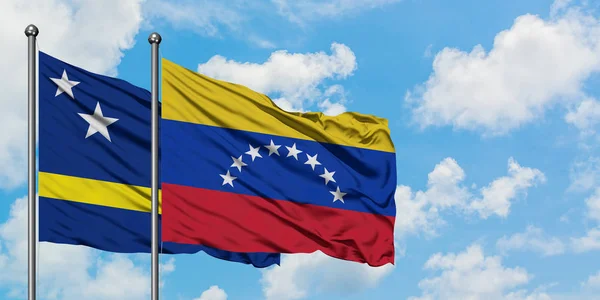 Curacao i Wenezuela Flaga Macha w wiatr przed białym zachmurzone błękitne niebo razem. Koncepcja dyplomacji, stosunki międzynarodowe. — Zdjęcie stockowe