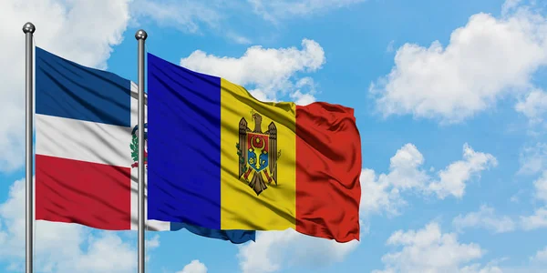 Bandera de República Dominicana y Moldavia ondeando en el viento contra el cielo azul nublado blanco juntos. Concepto diplomático, relaciones internacionales . — Foto de Stock