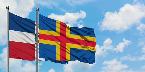 Dominikanska republiken och Åland sjunker vifta i vinden mot vit grumlig blå himmel tillsammans. Diplomatisk koncept, internationella relationer. — Stockfoto