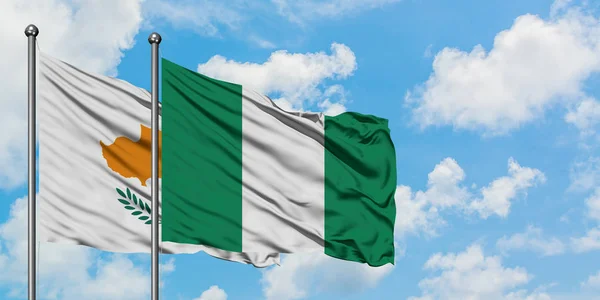 Cipro e Nigeria bandiera sventolando nel vento contro bianco cielo blu nuvoloso insieme. Concetto di diplomazia, relazioni internazionali . — Foto Stock