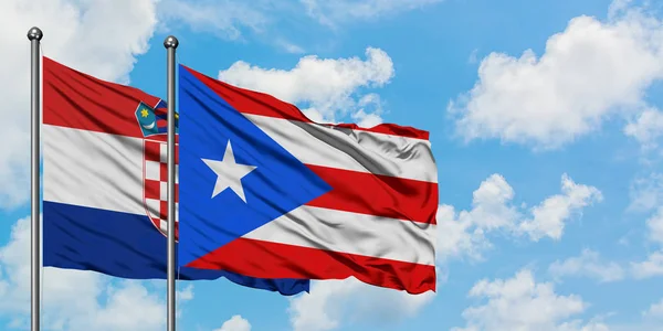 Kroatien und Puerto Rico schwenken gemeinsam die Flagge im Wind vor dem wolkenverhangenen blauen Himmel. Diplomatie-Konzept, internationale Beziehungen. — Stockfoto