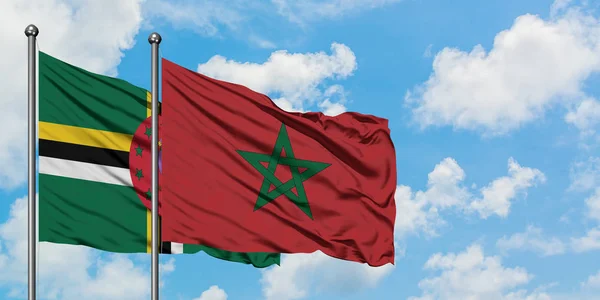 Bandera de Dominica y Marruecos ondeando en el viento contra el cielo azul nublado blanco juntos. Concepto diplomático, relaciones internacionales . — Foto de Stock