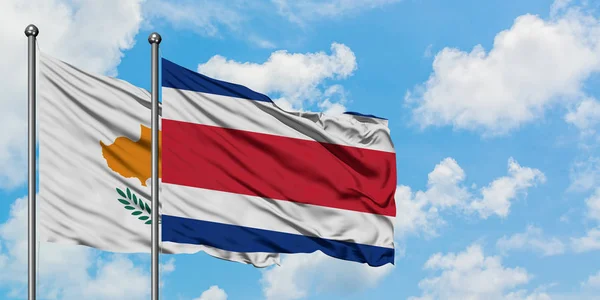 Кіпр і Коста-Ріка прапор розмахуючи в вітру проти білого хмарного синього неба разом. Концепція дипломатії, міжнародні відносини. — стокове фото