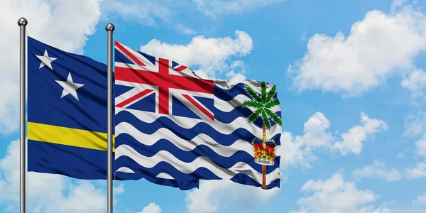 Curacao és brit indiai-óceáni terület zászló integetett a szél ellen, fehér felhős kék ég együtt. Diplomáciai koncepció, nemzetközi kapcsolatok. — Stock Fotó