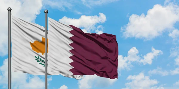 Bandera de Chipre y Qatar ondeando en el viento contra el cielo azul nublado blanco juntos. Concepto diplomático, relaciones internacionales . — Foto de Stock