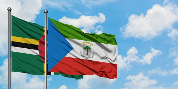 Dominica e a bandeira da Guiné Equatorial agitando no vento contra o céu azul nublado branco juntos. Conceito de diplomacia, relações internacionais . — Fotografia de Stock