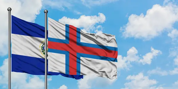 Сальвадор і Фарерські острови прапор розмахуючи в вітру проти білого хмарного синього неба разом. Концепція дипломатії, міжнародні відносини. — стокове фото
