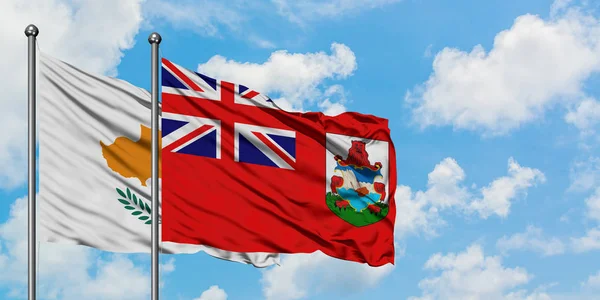 Bandera de Chipre y Bermudas ondeando en el viento contra el cielo azul nublado blanco juntos. Concepto diplomático, relaciones internacionales . — Foto de Stock