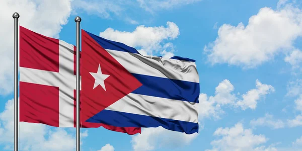 Dánsko a Kubánská vlajka mávali ve větru proti bíle zatažené modré obloze. Diplomacie, mezinárodní vztahy. — Stock fotografie