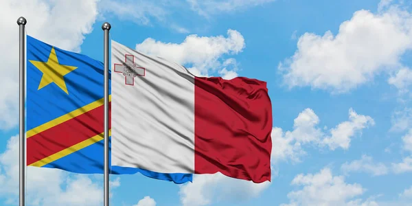 Bandera del Congo y Malta ondeando en el viento contra el cielo azul nublado blanco juntos. Concepto diplomático, relaciones internacionales . — Foto de Stock
