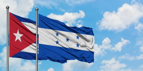 Η σημαία της Κούβας και της Ονδούρας κουνώντας τον άνεμο εναντίον του λευκού νεφελώδη μπλε ουρανού μαζί. Φιλοσοφία της διπλωματίας, διεθνείς σχέσεις. — Φωτογραφία Αρχείου