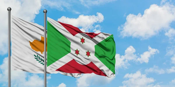 Cypern och Burundi flagga vifta i vinden mot vit grumlig blå himmel tillsammans. Diplomatisk koncept, internationella relationer. — Stockfoto