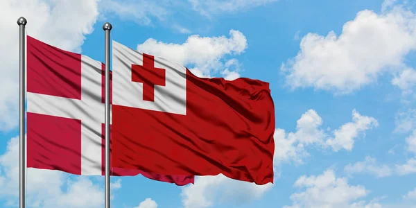 丹麦和汤加国旗在风中飘扬，白云蓝天相通。外交概念、国际关系. — 图库照片