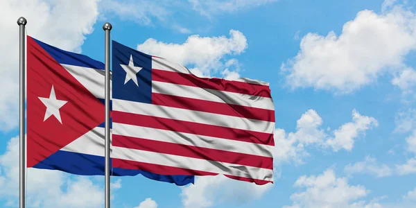 キューバとリベリアの旗は、一緒に白い曇り青い空に対して風に手を振る。外交概念、国際関係. — ストック写真