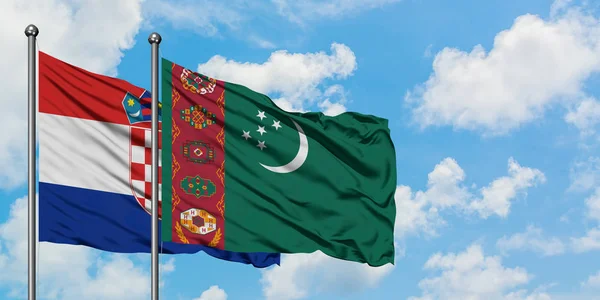 Bandera de Croacia y Turkmenistán ondeando en el viento contra el cielo azul nublado blanco juntos. Concepto diplomático, relaciones internacionales . — Foto de Stock