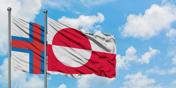 Les îles Féroé et le Groenland brandissent dans le vent contre le ciel bleu nuageux blanc ensemble. Concept de diplomatie, relations internationales . — Photo