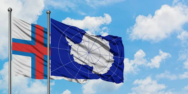 Фарерські острови і Антарктида прапор махав на вітрі від білого хмарного синього неба разом. Концепція дипломатії, міжнародні відносини. — стокове фото