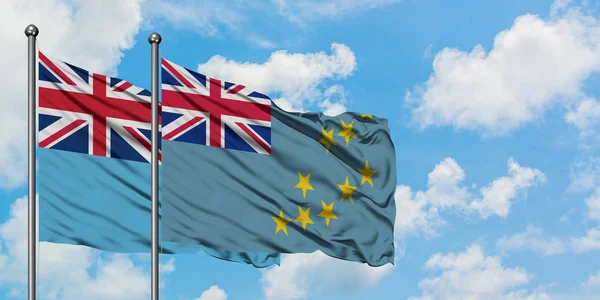 Bandera de Fiji y Tuvalu ondeando en el viento contra el cielo azul nublado blanco juntos. Concepto diplomático, relaciones internacionales . — Foto de Stock