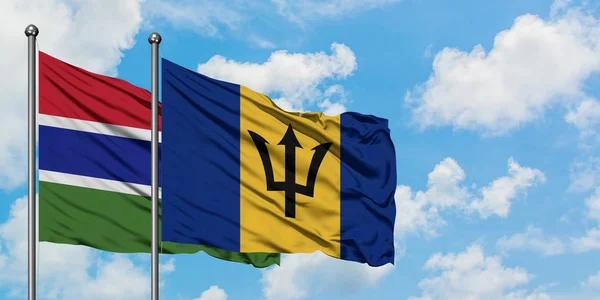 Gambia och Barbados flagga viftande i vinden mot vit grumlig blå himmel tillsammans. Diplomatisk koncept, internationella relationer. — Stockfoto