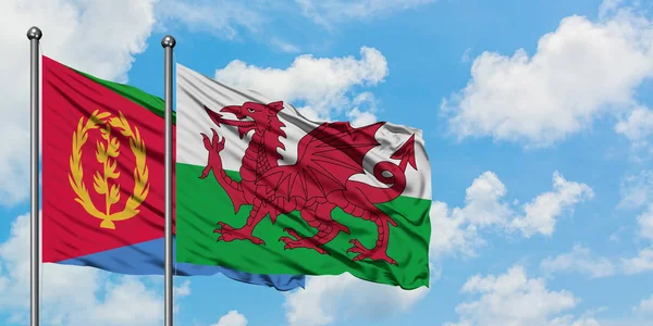 Eritre ve Galler bayrağı birlikte beyaz bulutlu mavi gökyüzüne karşı rüzgarda sallayarak. Diplomasi kavramı, uluslararası ilişkiler.