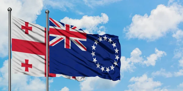 格鲁吉亚和库克群岛国旗在风中飘扬，与白云蓝天相得飞。外交概念、国际关系. — 图库照片