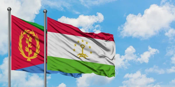 Bandera de Eritrea y Tayikistán ondeando en el viento contra el cielo azul nublado blanco juntos. Concepto diplomático, relaciones internacionales . — Foto de Stock