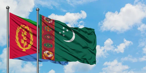 Bandera de Eritrea y Turkmenistán ondeando en el viento contra el cielo azul nublado blanco juntos. Concepto diplomático, relaciones internacionales . — Foto de Stock