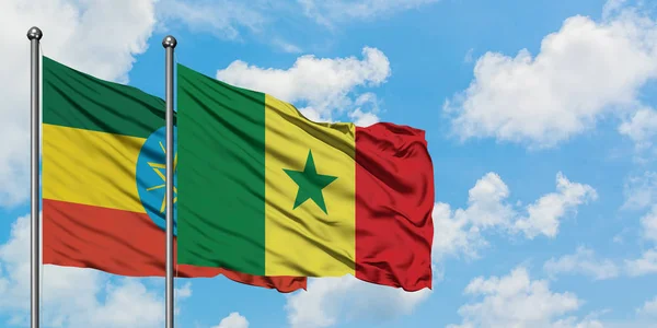 Bandera de Etiopía y Senegal ondeando en el viento contra el cielo azul nublado blanco juntos. Concepto diplomático, relaciones internacionales . — Foto de Stock