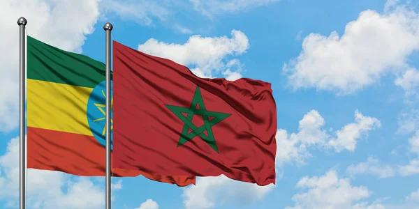Bandera de Etiopía y Marruecos ondeando en el viento contra el cielo azul nublado blanco juntos. Concepto diplomático, relaciones internacionales . — Foto de Stock