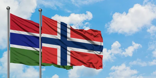 Bandera de Gambia y Noruega ondeando en el viento contra el cielo azul nublado blanco juntos. Concepto diplomático, relaciones internacionales . — Foto de Stock