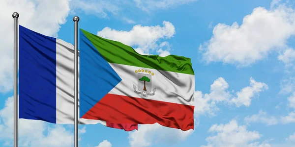 Bandera de Francia y Guinea Ecuatorial ondeando en el viento contra el cielo azul nublado blanco juntos. Concepto diplomático, relaciones internacionales . — Foto de Stock