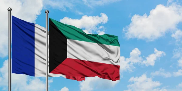 Bandera de Francia y Kuwait ondeando en el viento contra el cielo azul nublado blanco juntos. Concepto diplomático, relaciones internacionales . — Foto de Stock