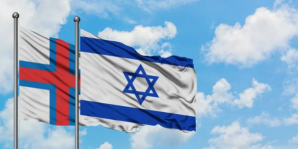 Bandera de las Islas Feroe e Israel ondeando en el viento contra el cielo azul nublado blanco juntos. Concepto diplomático, relaciones internacionales . —  Fotos de Stock