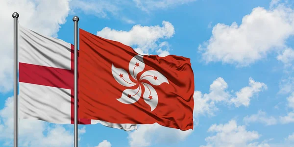 Bandera de Inglaterra y Hong Kong ondeando en el viento contra el cielo azul nublado blanco juntos. Concepto diplomático, relaciones internacionales . —  Fotos de Stock