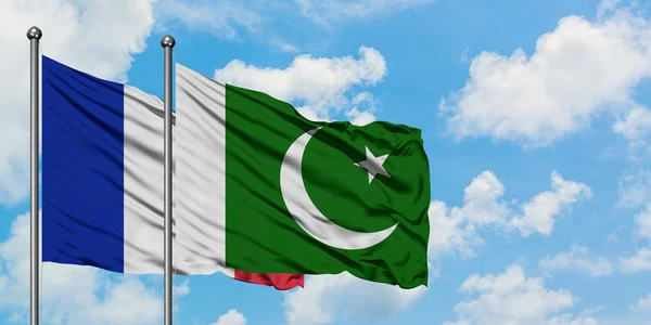 Francie a Pákistán vlají ve větru proti bíle zatažené modré obloze. Diplomacie, mezinárodní vztahy. — Stock fotografie