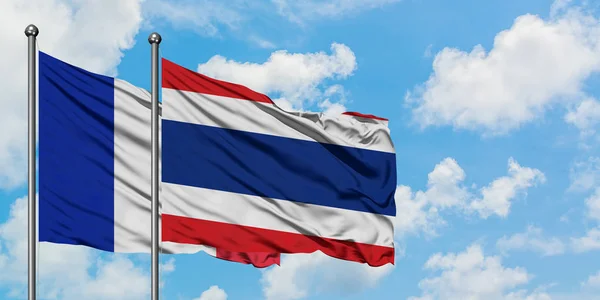 Флаг Франции и Таиланда, размахивающий ветром против белого облачного голубого неба. Концепция дипломатии, международные отношения . — стоковое фото
