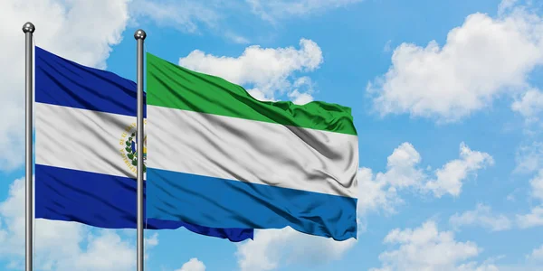 El salvador und sierra leone flagge wehen gemeinsam im wind vor weißem wolkenblauem himmel. Diplomatie-Konzept, internationale Beziehungen. — Stockfoto